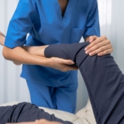 Therapist stretching leg of patient