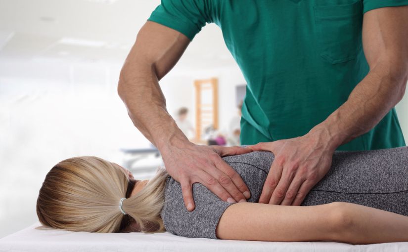 chiropractor doing spinal adjustment on patient