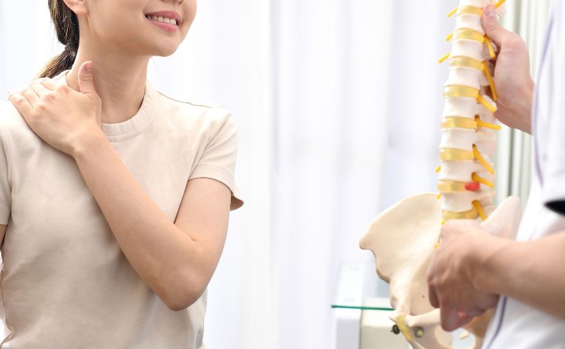 Female patient being shown spine model