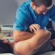 chiropractor stretching a male patient