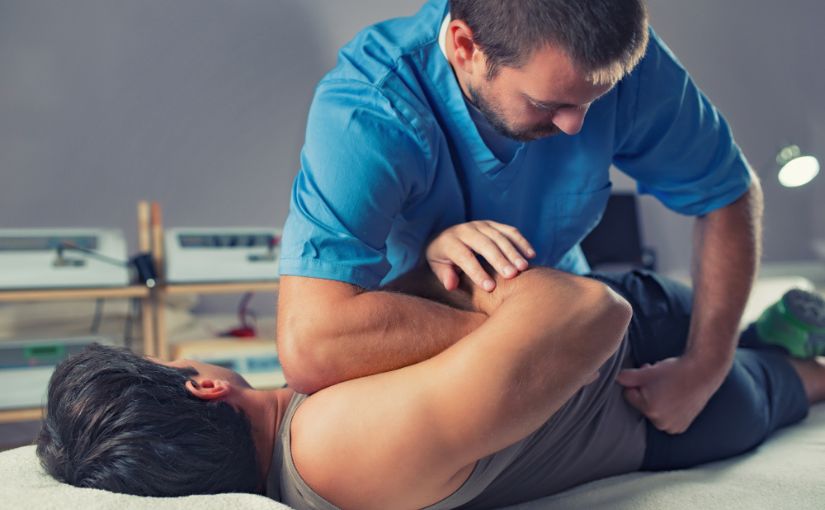 chiropractor stretching a male patient